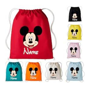 May include: A collection of drawstring bags in red, black, yellow, pink, teal, orange, white, and light blue. Each bag features a graphic of Mickey Mouse's face and the word Name printed in white or black text with white drawstring cords.