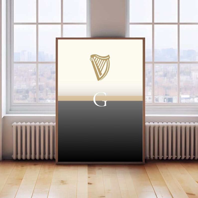 Guinness inspired “Split the G” poster leaning against large window interior, natural daylight reflecting on framed minimalist cream and black pint design, golden harp logo at top, bold Irish wall art, stylish Guinness fan décor, beer lover gift print, perfect for pubs, kitchens, man caves or living rooms, minimalist typography artwork celebrating Irish culture, sophisticated décor piece for modern interiors.