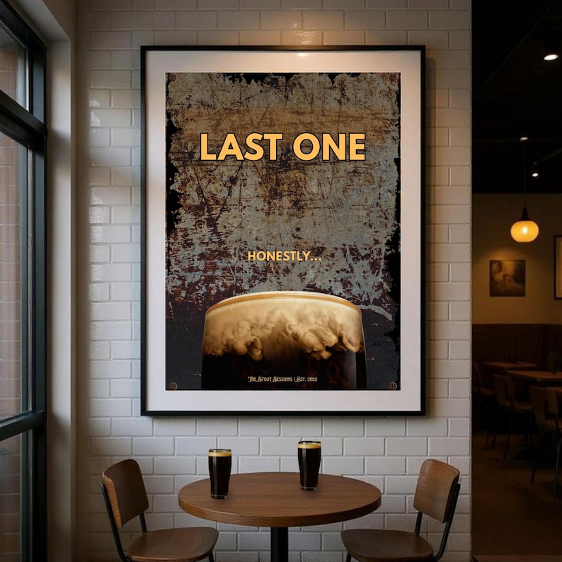 Framed dark humour wall art print reading Last One displayed in a cosy pub style interior with warm lighting and vintage textures, stout beer inspired artwork ideal for home bar decor, pub wall art, kitchen wall decor, man cave interiors and gifts for beer lovers who appreciate bold typography and understated humour
