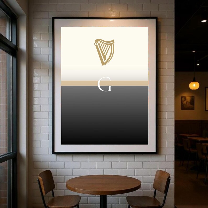 Modern framed Guinness inspired “Split the G” poster wall art hanging in a stylish café interior, minimalist black and cream design with golden harp icon, perfect Irish pub décor and beer lover gift print, ideal for Guinness fans who want contemporary artwork to celebrate Irish culture, displayed in cosy dining setting with industrial brick and wood textures for strong home or bar décor styling.