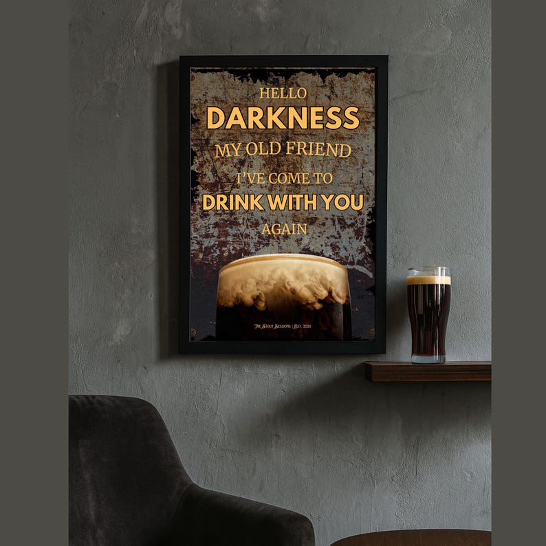 Hello Darkness” Guinness pint poster displayed on a minimalist wall-mounted shelf with a modern chair below, showcasing clean design and a sophisticated vibe, ideal for contemporary bar or lounge wall styling.