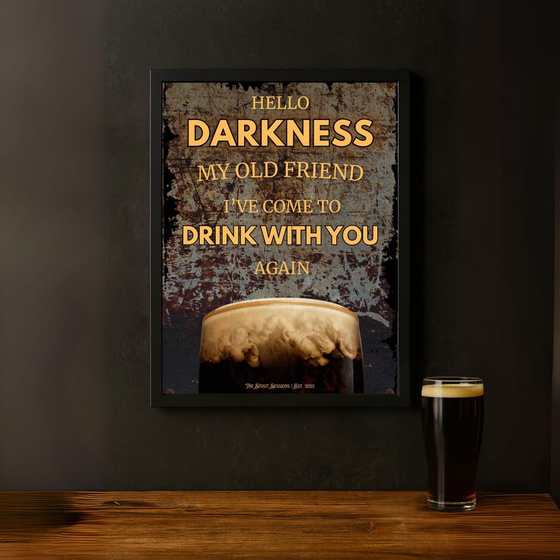 Hello Darkness My Old Friend” framed Guinness-inspired poster displayed in a moody home bar setting on a dark wall, paired with a single pint glass on a wooden shelf, creating a sleek and masculine vibe for beer lovers.