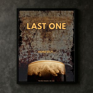 Framed Last One wall art print displayed above a wooden surface with a glass of stout, highlighting a moody pub inspired aesthetic, suitable for bar wall art, kitchen decor, home bars and contemporary rustic interiors
