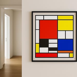 May include: A framed abstract art print with a geometric design. It features blocks of red, yellow, blue, black, and white. The artwork is in a black frame and hangs on a white wall. The artwork is a modern piece.