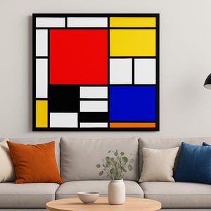 Può includere: Un'opera d'arte astratta incorniciata con un bordo nero, con audaci blocchi di rosso, giallo, blu, nero e bianco. L'opera è appesa sopra un divano beige con cuscini colorati. Una lampada moderna è di lato.