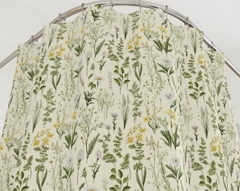 May include: A shower curtain with a floral pattern featuring various green leaves and white and yellow flowers on a cream background.