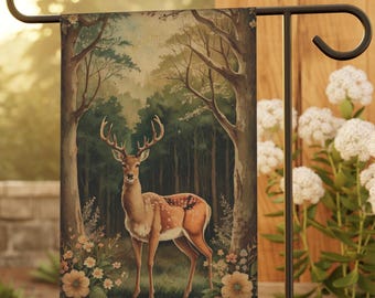 May include: A garden flag featuring a vintage illustration of a deer standing in a woodland setting. The deer is brown with white spots and has large antlers. The background is a watercolour painting of a forest with green trees and a light blue sky.