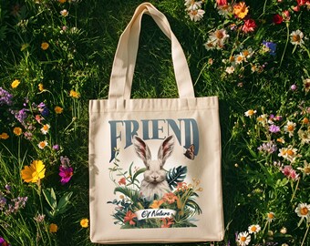 Peut inclure: Sac fourre-tout crème avec le mot "FRIEND" en bleu et une illustration de lapin. Le lapin est entouré de fleurs et de verdure, avec un papillon à droite. Les mots "Of Nature" sont en dessous du lapin.