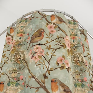 May include: A shower curtain with a floral pattern featuring pink flowers and robins. The background is a light blue colour.