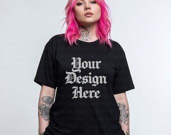 Op de afbeelding: Zwart T-shirt met de tekst "Your Design Here" in een gotisch lettertype. Het model heeft roze haar en tatoeages. Het T-shirt is een klassieke ronde hals.