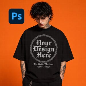 May include: A black short-sleeved t-shirt featuring a circular frame with the text Your Design Here in a gothic font. Below the circle, the text The Gothic Merchant is printed above a small leaf graphic. The shirt has a crew neckline.