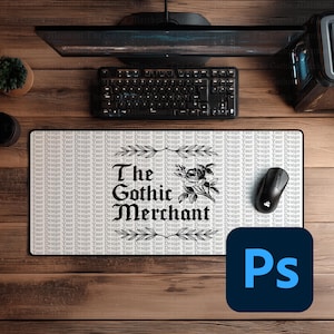 May include: A rectangular mouse pad with the text "The Gothic Merchant" in a gothic font, with a floral design. The pad is on a wooden desk, with a keyboard, mouse, and monitor visible.