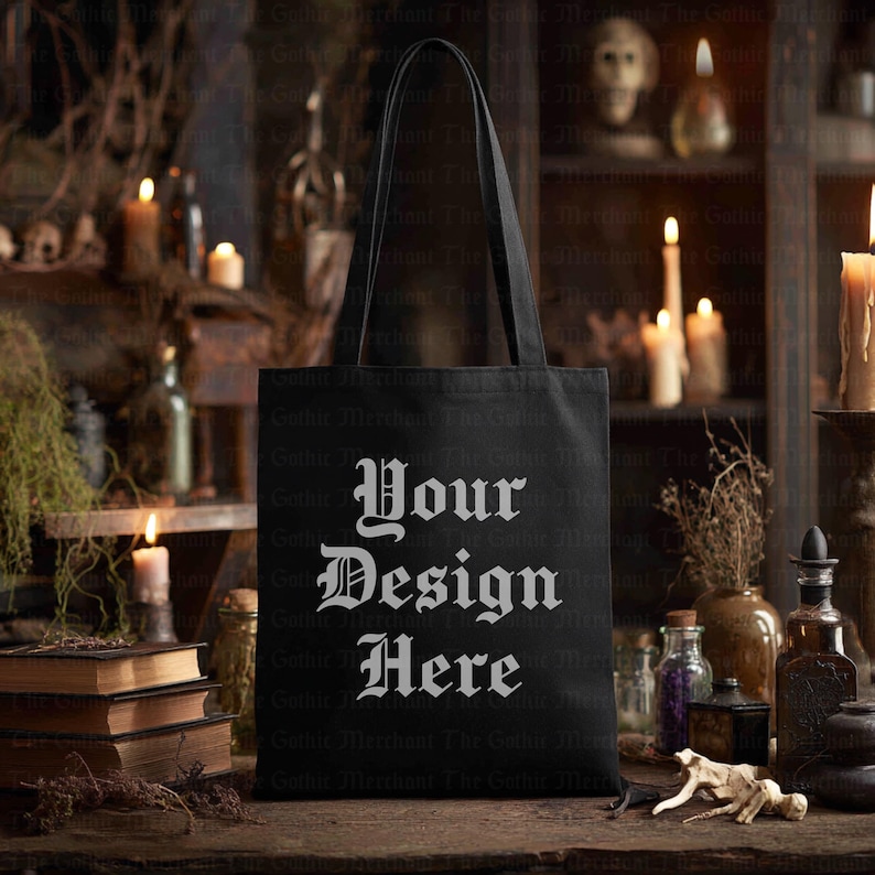 May include: Black tote bag with the text "Your Design Here" in a gothic font. The bag has long handles and is displayed on a wooden surface. The background includes candles, books, and apothecary bottles.