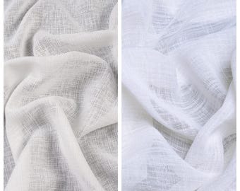 Puede incluir: Dos muestras de tela, una etiquetada como "CHAMPAGNE" y la otra como "SNOW LINE". La muestra "CHAMPAGNE" es de color beige claro, mientras que la muestra "SNOW LINE" es de color blanco brillante. Ambas telas tienen un aspecto texturizado y tejido, con hilos visibles y una caída suave.