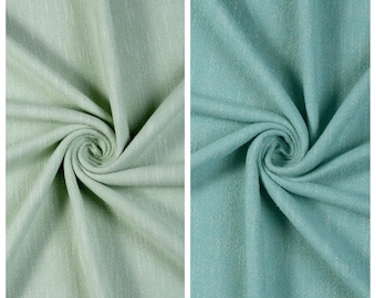 May include: Two swatches of fabric displayed side-by-side. The left swatch is light green with the text PINEAPPLE LEAF above it. The right swatch is teal with the text DELICATE above it. Both fabrics feature a visible woven texture.