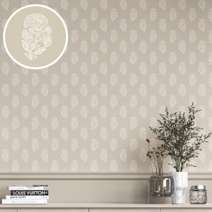 May include: Beige wallpaper with a repeating white floral pattern. A circular inset shows a close-up of a single white floral design. The wallpaper is installed above a neutral-toned cabinet, with books and decorative items.