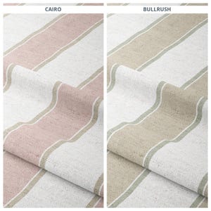 May include: Two fabric samples with diagonal stripes. The left sample, labelled "CAIRO", has pink, white, and tan stripes. The right sample, labelled "BULLRUSH", has tan, white, and green stripes. Both have a textured appearance.