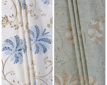 Può includere: Due pannelli di tessuto con motivi botanici ricamati. Il pannello sinistro, etichettato SURFS UP, è bianco con motivi floreali blu e marrone chiaro. Il pannello destro, etichettato COLD FLINT, è grigio con ricami floreali bianchi e color rame.