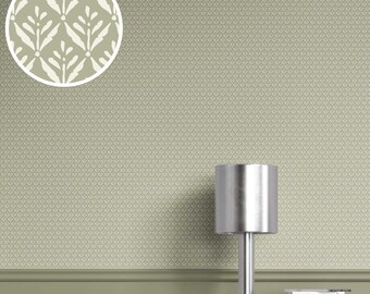 May include: A close-up of a sage green wallpaper with a repeating geometric pattern. A circular inset shows a leaf-like design. A silver lamp with a cylindrical shade sits on a light-colored cabinet. Books with the titles "Louis Vuitton" and "Pierre Cardin" are visible.