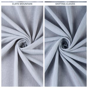 Könnte beinhalten: Zwei Stoffmuster in hellblau. Der Stoff ist eine Leinenmischung mit einer dezenten Textur. Die Muster sind mit "Cliffs Mountain" und "Shifting Clouds" beschriftet.