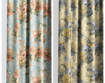 May include: Two floral patterned curtains. The left curtain has a light blue background with peach and cream-colored roses. The right curtain has a yellow background with blue and yellow roses. The text "DAPOLI" and "SUNDAY ANGEL" are at the top.