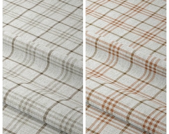 May include: Two fabric samples with plaid patterns. The left sample, labeled "Dreamy Cane," features a light gray and brown plaid. The right sample, labeled "Solitaire Sheen," displays a light gray and orange-brown plaid. Both fabrics have a textured appearance.