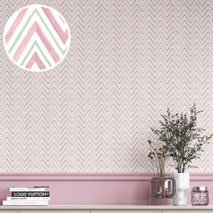 May include: Pink and white chevron patterned wallpaper. A close-up shows a watercolor detail of pink and green chevron stripes. The wallpaper is installed on a wall above a pink painted trim. Decorative items are on a shelf.