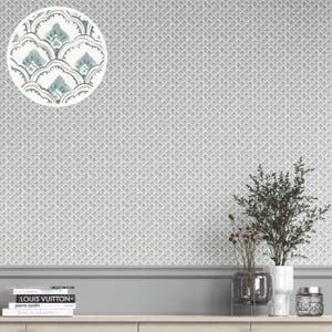 Peut inclure: Papier peint gris clair avec un motif répétitif de petites formes de feuilles stylisées. Un encart circulaire montre un gros plan du motif en blanc, sarcelle et marron. Le papier peint est sur un mur avec une plinthe grise et une étagère en bois.