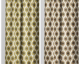 May include: Two patterned curtain panels. The left panel is labeled "SERENITY CLOVER" and features a repeating geometric design in shades of gold, olive green, and gray. The right panel, labeled "WHEAT CONE," has a similar pattern in brown and beige.