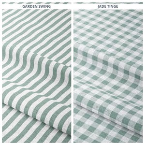 May include: Two fabric samples. The left sample features a pattern of diagonal, alternating white and seafoam green stripes. The right sample displays a classic gingham check pattern in the same seafoam green and white color scheme. The text "GARDEN SWING" and "JADE TINGE" are visible.