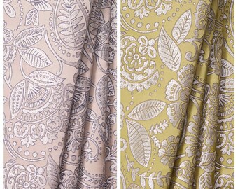 May include: Two fabric swatches with a floral pattern. The fabric on the left is a light pink with a silver floral pattern. The fabric on the right is a light yellow with a silver floral pattern. The fabric swatches are labeled "Pisces" and "Garlic Pod".