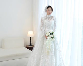 Vestido de novia de lujo con cuello alto, encaje y estilo real: mangas largas y bordados elaborados. Elegante y lujoso vestido de novia, personalizable en cualquier talla.