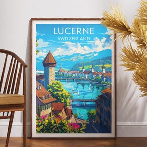 May include: A framed art print featuring a vibrant illustration of Lucerne, Switzerland. The artwork showcases a picturesque cityscape with a river, boats, and mountains under a bright blue sky. The print includes the text "LUCERNE SWITZERLAND".