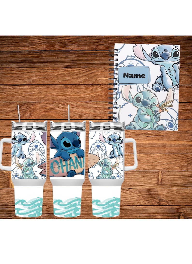 May include: A set of three white tumblers with handles and a matching spiral-bound notebook. Each tumbler features a blue cartoon character design with the word "OHANA" on a surfboard. The notebook has the word "Name" on it.
