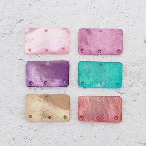 May include: Six rectangular plastic bookmarks with different marbled patterns. The bookmarks are in shades of pink, purple, teal, gold, and peach.