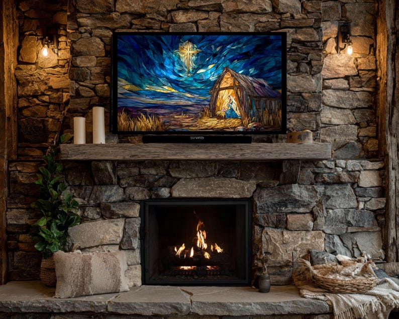 May include: A cozy fireplace with a stone facade. A lit fire is in the fireplace. A TV displays a stained-glass style image of a nativity scene. Candles and a small plant sit on the mantle. A basket and blanket are on the hearth.