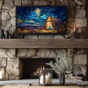 May include: A digital art print of a nativity scene is displayed on a black framed television above a stone fireplace. The artwork depicts a barn with a cross in the sky. The fireplace is decorated with candles, vases, and a wooden mantel.