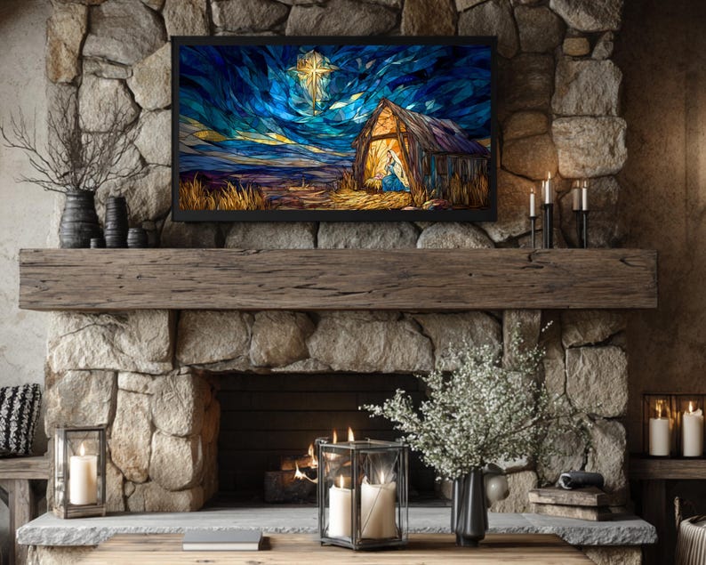 May include: A digital art print of a nativity scene is displayed on a black framed television above a stone fireplace. The artwork depicts a barn with a cross in the sky. The fireplace is decorated with candles, vases, and a wooden mantel.