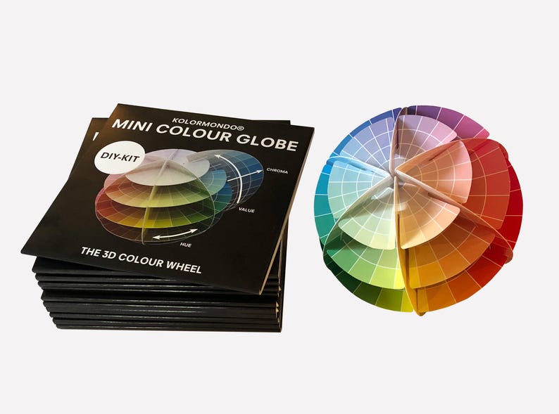 May include: A black and white DIY kit for a mini color globe. The kit includes a color wheel with the words "DIY-KIT", "The 3D Color Wheel", "KOLORMUNDO", "MINI COLOUR GLOBE", "HUE", "VALUE", and "CHROMA". The kit also includes a color globe that is assembled and shows the colors of the color wheel.