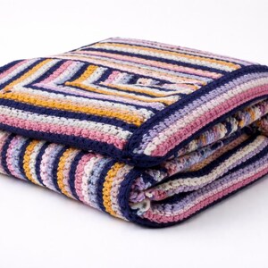 May include: Folded crochet blanket with a striped pattern in shades of pink, purple, yellow, and white, bordered with navy blue. The blanket is neatly folded, showcasing the intricate stitch work and color arrangement.