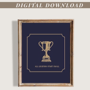 May include: A framed print with a navy blue background and a gold trophy illustration. The text "ALL LEGENDS START SMALL" is below the trophy. The words "DIGITAL DOWNLOAD" are at the top.