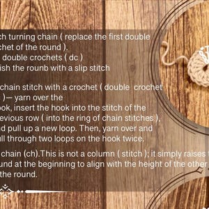 Peut inclure: Tutoriel de crochet avec des instructions pour le tour 2, comprenant des mailles en l'air et des brides. L'image montre une pi&egrave;ce de crochet partiellement termin&eacute;e et du texte sur un fond en bois.