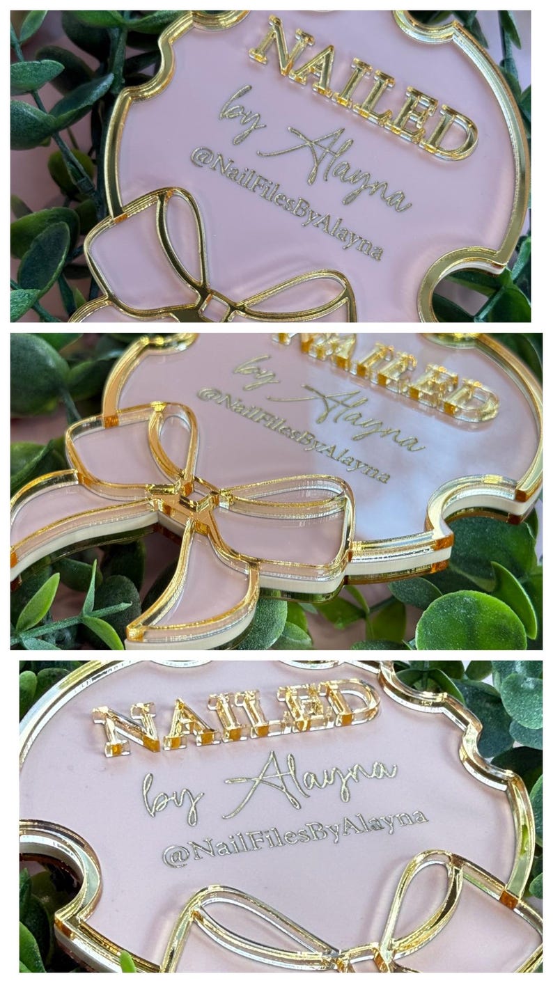 May include: A pink and gold decorative sign with the text "NAILED by Alayna" and the Instagram handle "@NailFilesByAlayna". The sign has a bow design and a gold border.