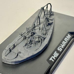 Puede incluir: Un modelo 3D impreso en gris de una montaña rusa llamada "The Swarm".