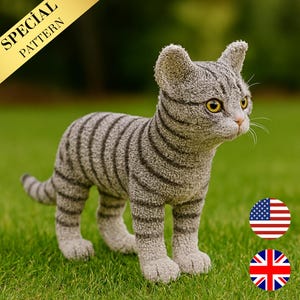 Può includere: Una statuetta di gatto tabby grigio con strisce grigio scuro, occhi gialli e naso rosa, in piedi sull'erba verde. Il gatto ha un aspetto strutturato. Uno striscione dorato nell'angolo in alto a sinistra recita "SPECIAL PATTERN".