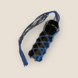 May include: A blue crocheted water bottle holder with a long strap and a tassel. The holder is designed to fit a standard-sized water bottle.