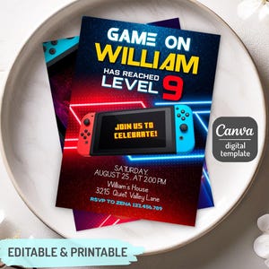 以下が含まれることがあります： ゲームをテーマにしたデジタル招待状。デザインは、赤と青のアクセントが付いたゲームコンソールのイラストが特徴です。「Game On William」、「Level 9」、パーティーの詳細などのテキストが含まれています。招待状には「編集可能で印刷可能」と記載されています。