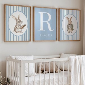 May include: Three framed prints with a blue and white striped background. The center print features a large white letter "R" with the name "ROGER" below it. The prints on either side feature a cartoon bunny wearing a suit and glasses.