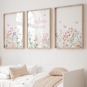 Puede incluir: Tres impresiones artísticas enmarcadas con diseños florales en acuarela en tonos rosa, azul y verde suaves. Las impresiones presentan mariposas y el texto "Custom TEXT OR VERSE" en la impresión central. Los marcos son de color marrón claro.