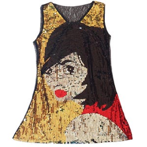 Könnte beinhalten: Ärmelloses Paillettenkleid mit stilisiertem Gesichtsdesign. Das Kleid hat einen schwarzen Spitzenausschnitt und ist mit goldenen, schwarzen und roten Pailletten verziert. Das Design zeigt ein Frauengesicht mit roten Lippen und dunklem Haar.